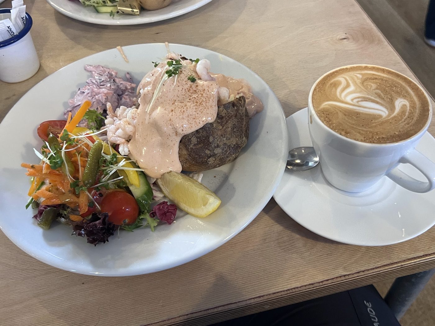 A plate with salmon and salad, and a latte